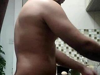 A bald man washes dishes in a gay hardcore video