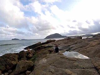 Detailed blowjob scene with big tits in voyeur setting on rocks