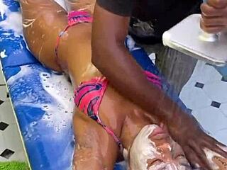 Beautiful woman gives a sensual massage with oil to her man