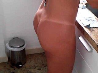 She's in the kitchen wearing a bikini.