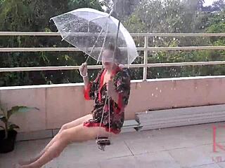 Verdorbene Hausfrau ohne Slip unter Schirm im Vintage-Nackt-Scene