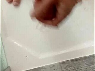 I'm showering my hard cock in the bathroom, feeling the water cascade over my muscular bodybuilder frame with blue eyes.