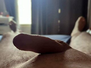 I'm stroking my big cock solo in the bedroom with sun rays filtering through the window.
