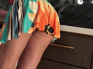 Young brunette babe strips panties under skirt in kitchen