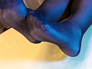 Sexy goddess in black pantyhose with rose print on heels teases you with her feet and toes