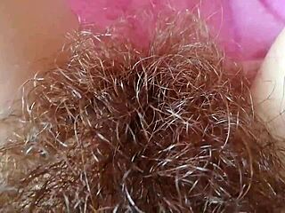 Hairy pussy with big clit and lips up close, all wet and grooly.