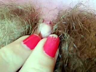 Hairy pussy with big clit and lips up close, all wet and grooly.