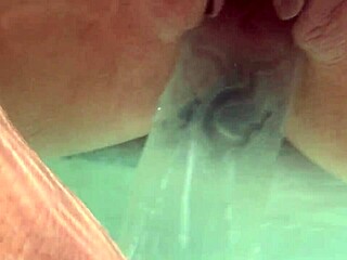 underwater scene shows creampie with dildo inserted in shaved pussy