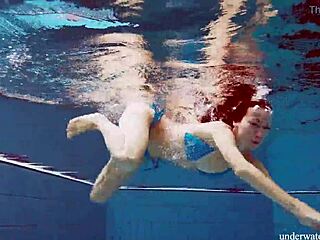 Brunette teen Martina swims underwater in blue bikini at the beach. Her tight pussy shows through in outdoor European pool shower.