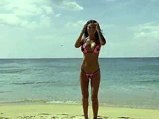 Monika Fox poses solo in pink bikini on beach