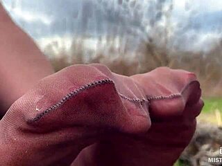 Goddess teases feet in pantyhose amid spring forest