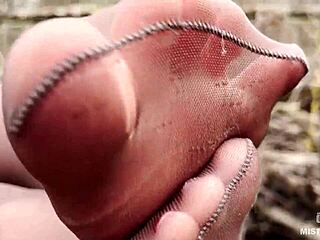 Goddess teases feet in pantyhose amid spring forest